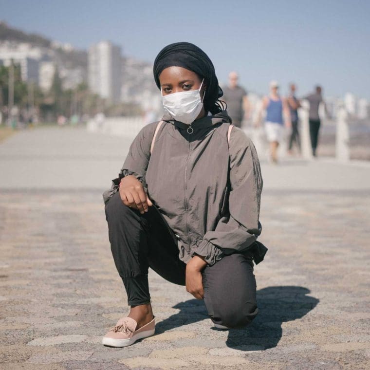 ethnic female in outerwear and protective mask squatting on 4177646 scaled 1