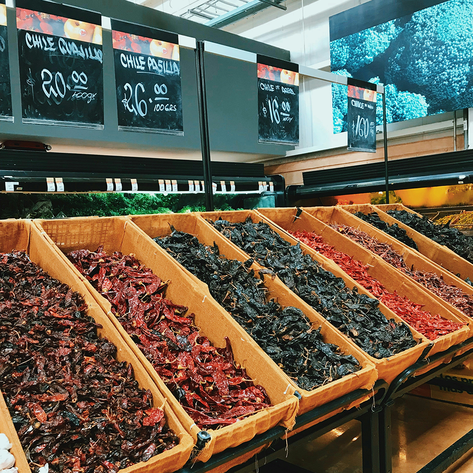 variety of dried chile peppers in bins